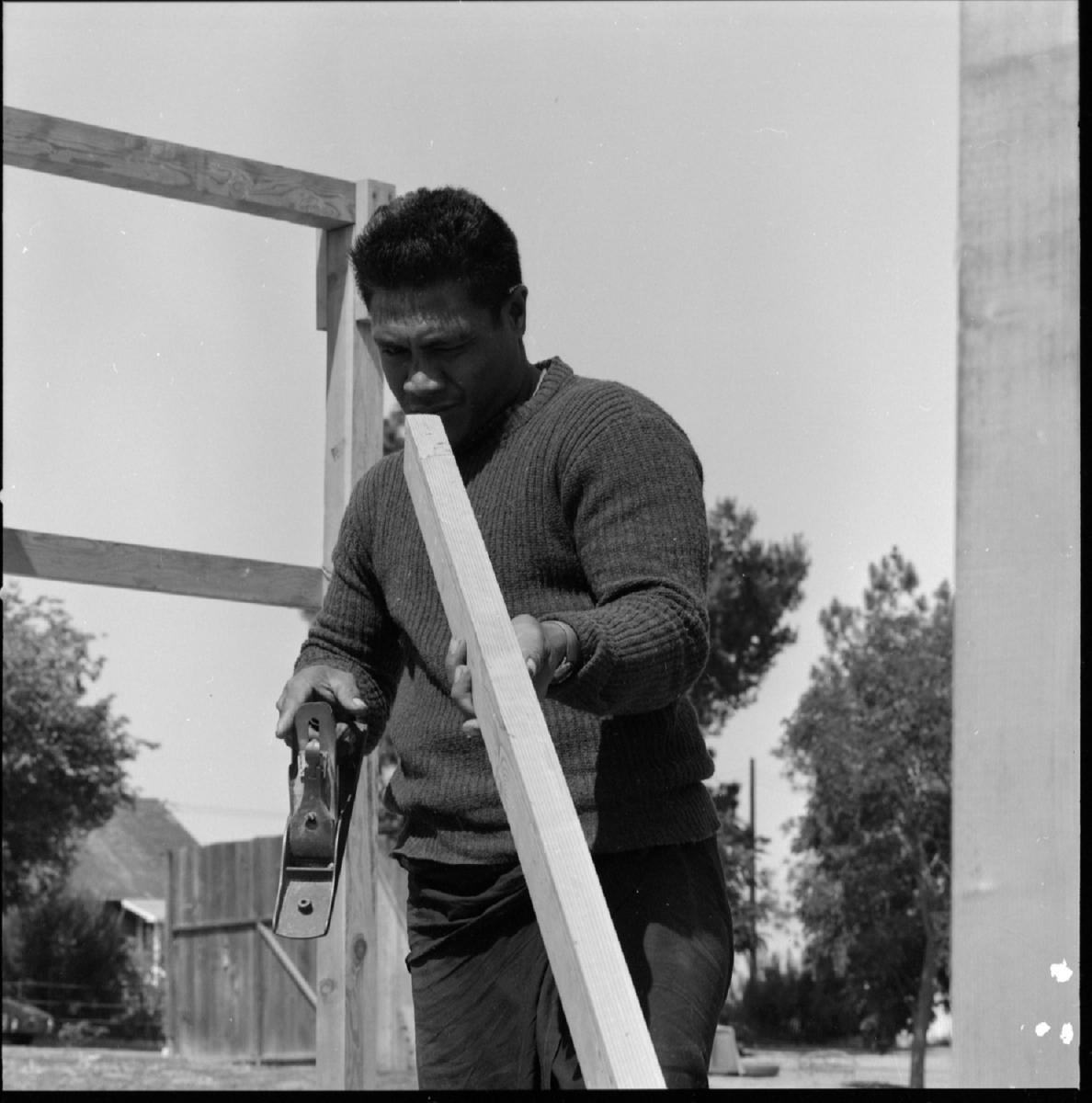 Taloolema'agao Uliulileava Olano inspecting wooden plank