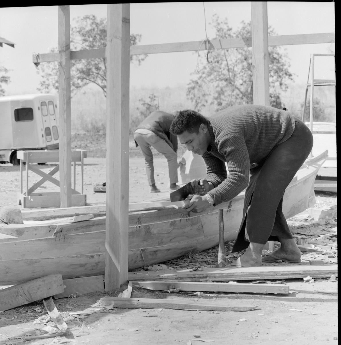 Taloolema'agao Uliulileava Olano sawing off wood at canoe