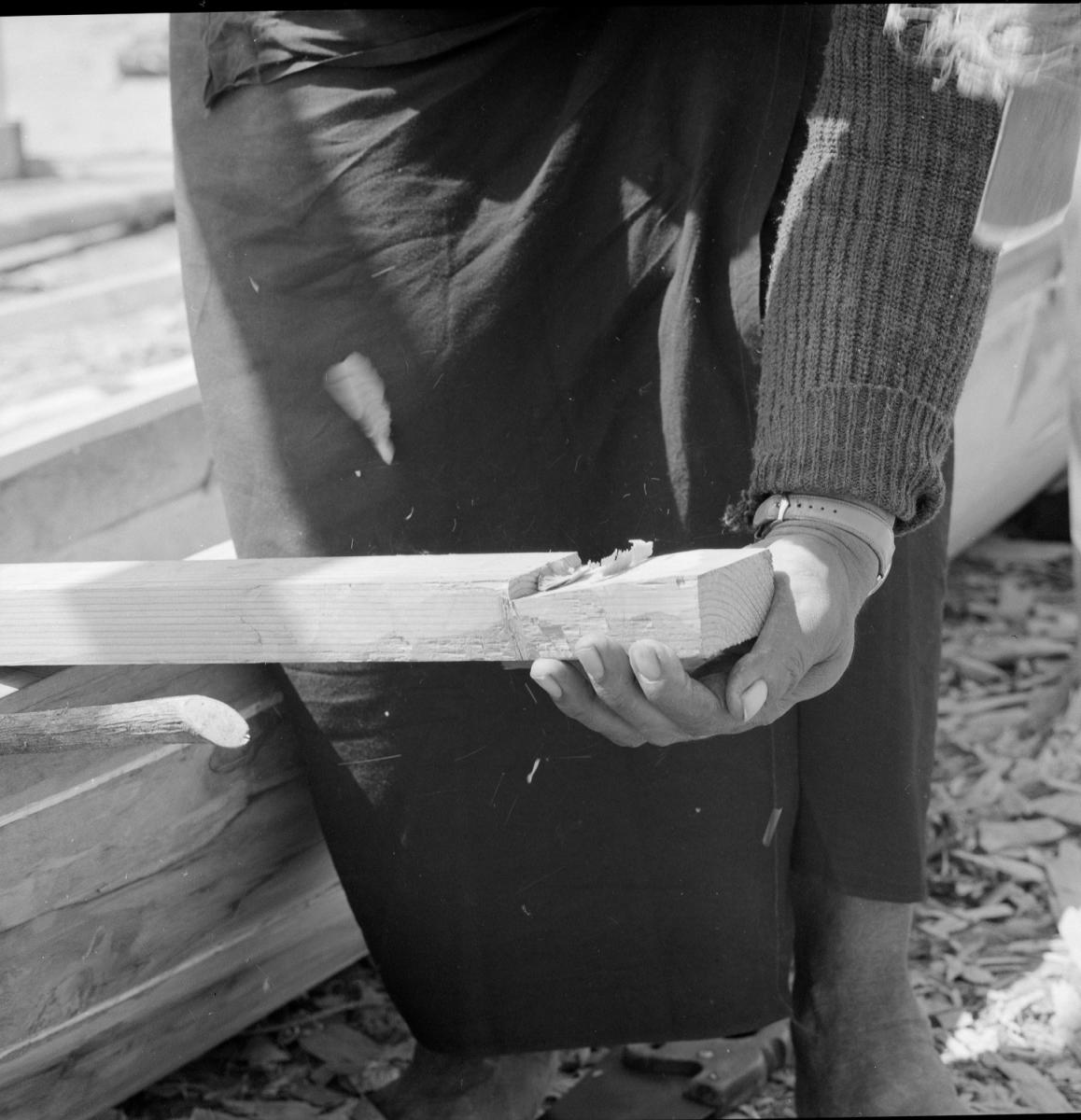 Taloolema'agao Uliulileava Olano inspecting sawed off wood